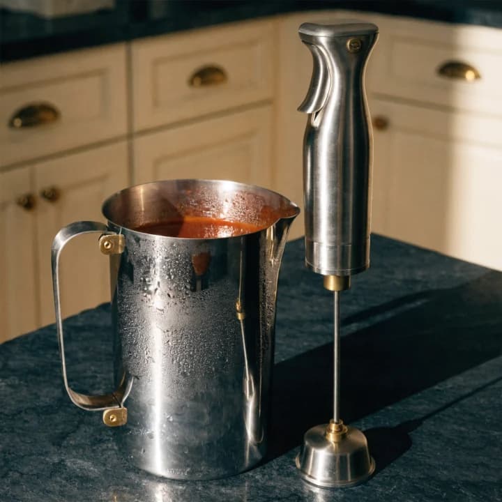 Immersion hand blender beside a blending jug