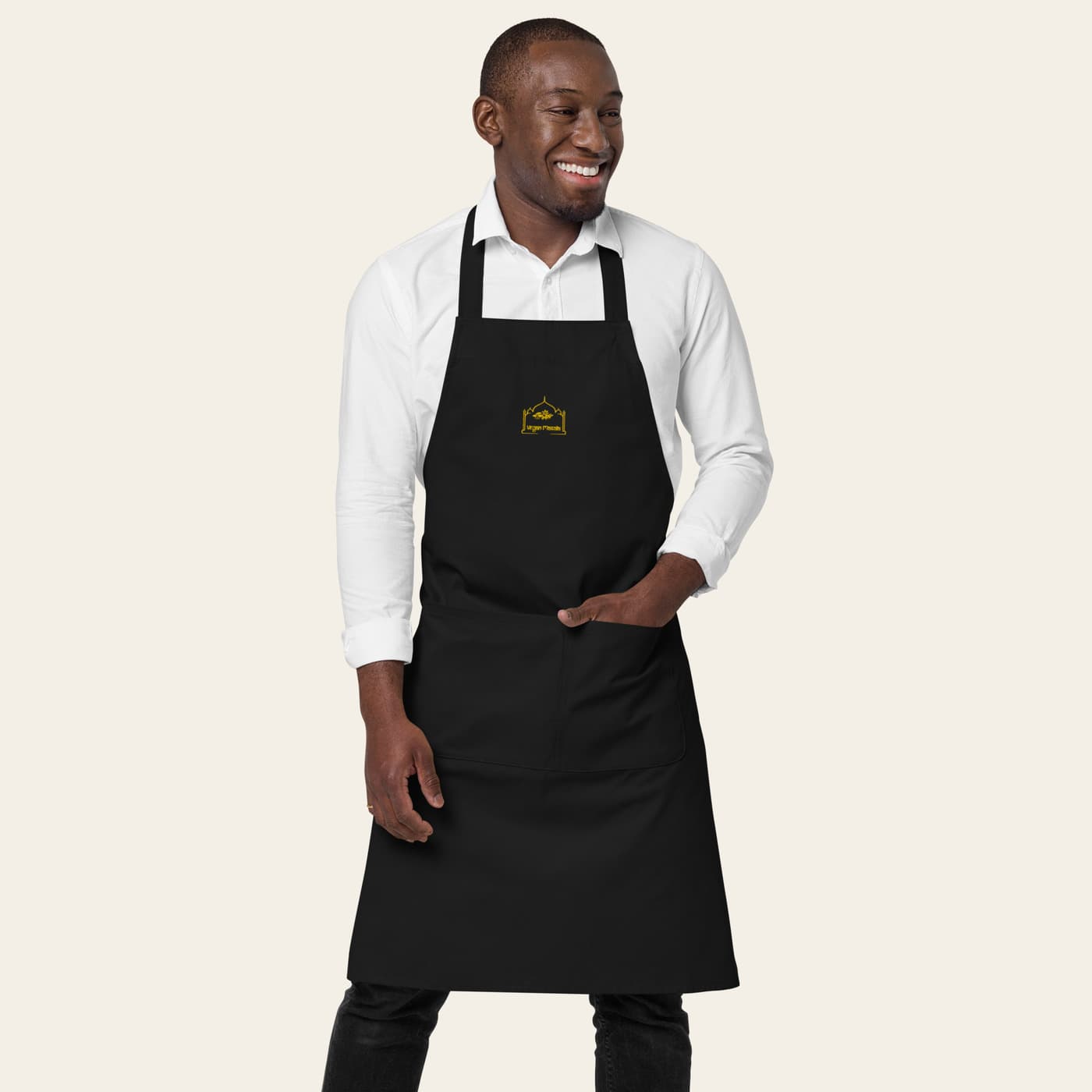 Model wearing the black Vegan Masala apron with its single-colour gold embroidered logo